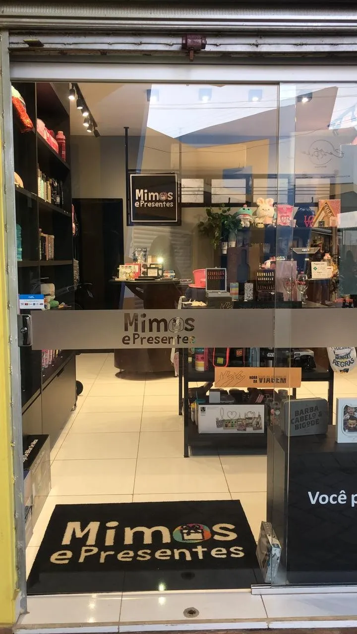 Entrada da Mimos Store, loja da Mimos e Presentes em Hidrolândia, com o tapete da marca e as prateleiras ao fundo